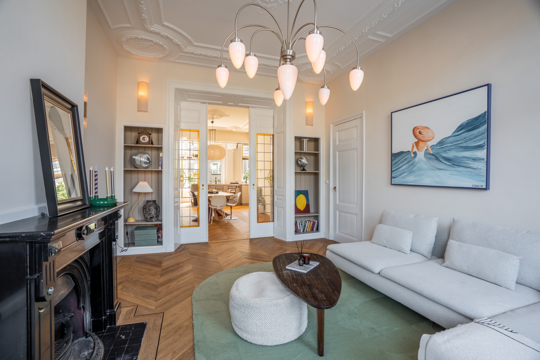 Woonkamer met sofa, schouw en ornamenten